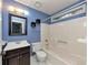 Cozy bathroom features a vanity, toilet, and a tub with shower, all complemented by blue walls at 916 Forest Pointe Way, Jonesboro, GA 30238