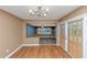 Bright dining room with wood floors, modern light fixture, and sliding glass doors leading outside at 916 Forest Pointe Way, Jonesboro, GA 30238