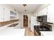 Galley kitchen featuring white cabinets, tile backsplash, and black appliances at 916 Forest Pointe Way, Jonesboro, GA 30238