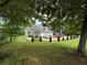 Exterior view of the stone home featuring a three-car garage and well-manicured front yard at 3393 Childers Ne Rd, Roswell, GA 30075