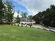 Landscaped front lawn of a stone accented house with a three-car garage at 3393 Childers Ne Rd, Roswell, GA 30075
