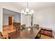 Dining room with modern chandelier, hardwood flooring, and vintage cabinet at 3431 Alcan Way, Tucker, GA 30084