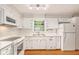 White kitchen features stainless steel appliances, a window, and shaker style cabinets at 3431 Alcan Way, Tucker, GA 30084
