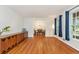 Sunlit living room with refinished wood floors, stylish cabinet, and open view to the dining area at 3431 Alcan Way, Tucker, GA 30084