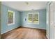 Well-lit bedroom with hardwood floors and neutral colored walls at 3517 Plunkett Rd, Stonecrest, GA 30038