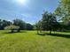 Lush backyard featuring bright green grass, scattered trees, and clear blue skies above at 3517 Plunkett Road Rd, Stonecrest, GA 30038