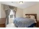 Comfortable bedroom with a wooden bed frame, nightstands, a ceiling fan and natural light from the window at 823 Mackay Crk, Woodstock, GA 30188