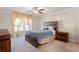 Comfortable bedroom with a wooden bed frame, nightstands, a ceiling fan and natural light from the window at 823 Mackay Crk, Woodstock, GA 30188