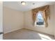 Empty bedroom featuring natural light from the window with neutral wall paint and plush carpet flooring at 823 Mackay Crk, Woodstock, GA 30188