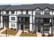 Modern townhomes featuring black and white exteriors, private balconies, and landscaped front yards at 823 Mackay Crk, Woodstock, GA 30188