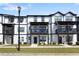 Modern townhouse featuring white siding, black trim, balconies, and well-maintained landscaping, exuding curb appeal at 823 Mackay Crk, Woodstock, GA 30188