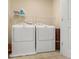Practical laundry area with a washer, dryer, and shelving for storage at 823 Mackay Crk, Woodstock, GA 30188
