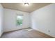 Well-lit bedroom features neutral carpet, fresh paint, and natural light from a window at 1071 N Village Dr, Decatur, GA 30032