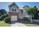Charming townhome featuring a two-car garage, landscaped yard, and a mix of brick and stone accents at 1071 N Village Dr, Decatur, GA 30032