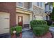 Close-up of townhome entrance, showcasing a stylish front door, manicured shrubs, and convenient two-car garage at 1071 N Village Dr, Decatur, GA 30032