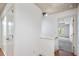 Hallway with white walls, hardwood floors, and views into a light-filled room at 1071 N Village Dr, Decatur, GA 30032