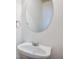 Close-up of the powder room with a modern floating sink, oval mirror, and chrome fixtures at 1071 N Village Dr, Decatur, GA 30032