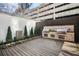 Stylish outdoor kitchen featuring stainless steel grills and a stone backsplash on a wooden deck at 199 14Th Ne St # 402, Atlanta, GA 30309