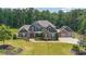 Aerial view of a large home with three-car garage, lush lawn, and mature trees at 265 Enfield Ln, Mcdonough, GA 30252