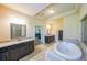 Bright bathroom featuring double vanity, soaking tub, and linen closet at 265 Enfield Ln, Mcdonough, GA 30252