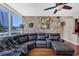 Living room featuring a comfortable leather sectional, a brick accent wall, and a ceiling fan at 3338 Peachtree Ne Rd # 508, Atlanta, GA 30326