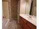 Bathroom featuring a tiled shower/tub, wood vanity with sink, mirror, and tile flooring at 3878 Hannahberry Pl, Buford, GA 30519
