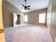 Spacious main bedroom with two windows, ceiling fan, neutral paint, and attached bathroom access at 3878 Hannahberry Pl, Buford, GA 30519