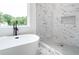 Bright bathroom featuring a luxurious soaking tub, marble tile shower, and a view to the outdoors at 1993 Reynolds Sw Dr, Atlanta, GA 30315