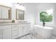 Elegant bathroom with double vanity, soaking tub, marble floors, and natural light at 1993 Reynolds Sw Dr, Atlanta, GA 30315