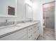 A bright bathroom with white marble counter, dual sinks, white cabinets, and marble shower at 1993 Reynolds Sw Dr, Atlanta, GA 30315