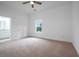 A bright bedroom with neutral carpet, ceiling fan, white trim, and a view to a bathroom at 1993 Reynolds Sw Dr, Atlanta, GA 30315