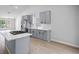 Chic kitchen featuring grey cabinetry, an island with bar seating, modern appliances and hardwood floors at 3156 Ozmer Lndg, Decatur, GA 30034