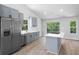 Modern kitchen with grey cabinets, stainless steel appliances, island and a large window showcasing the backyard at 3156 Ozmer Lndg, Decatur, GA 30034