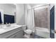 Bathroom with gray tiled shower and dark blue paneling, white cabinets, and stylish fixtures at 510 Cunninghame Ct, Peachtree City, GA 30269