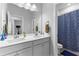 Bright bathroom featuring double sinks, white cabinetry, and a shower with patterned curtain at 510 Cunninghame Ct, Peachtree City, GA 30269