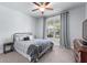Cozy bedroom with a metal frame bed, neutral decor, a ceiling fan, and a large window at 510 Cunninghame Ct, Peachtree City, GA 30269