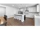 Well-lit kitchen with an island, stainless steel appliances, white cabinets and countertops, and hardwood floors at 510 Cunninghame Ct, Peachtree City, GA 30269