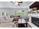 Bright living room featuring a fireplace, large windows, and a comfortable sectional sofa on hardwood floors at 510 Cunninghame Ct, Peachtree City, GA 30269