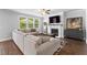 Cozy living room featuring a fireplace, large windows, and a comfortable sectional sofa on hardwood floors at 510 Cunninghame Ct, Peachtree City, GA 30269