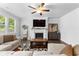 Cozy living room featuring a fireplace, large windows, and a comfortable sectional sofa on hardwood floors at 510 Cunninghame Ct, Peachtree City, GA 30269