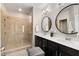 Modern bathroom featuring a glass shower, double sinks, and circular mirrors for a spa-like feel at 752 Winton Way, Atlanta, GA 30312