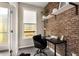 Cozy office with brick wall, shelves, black desk, and ample natural light at 752 Winton Way, Atlanta, GA 30312