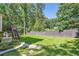 Green backyard with mature trees, a wooden fence, and a small patio with room to entertain at 3005 Park Chase, Alpharetta, GA 30022