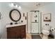 Updated bathroom offers a glass enclosed shower, modern vanity, and a stylish round mirror at 3005 Park Chase, Alpharetta, GA 30022