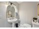 Powder room with pedestal sink, arched mirror, and modern lighting at 3005 Park Chase, Alpharetta, GA 30022