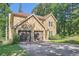 Side view of a stone-clad two-story home with a two-car garage and mature trees at 3005 Park Chase, Alpharetta, GA 30022