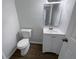 Cozy half bathroom features a white toilet, vanity and a hardwood floor at 3008 Pine Tree Trl # 16D, Atlanta, GA 30349