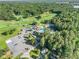 Community aerial showing golf course, clubhouse and pool surrounded by lush trees with parking and tennis courts at 1156 Magnolia Dr, Villa Rica, GA 30180