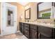 Bathroom with granite countertop, dual sinks, dark cabinets, and a large mirror with decorative frame at 1156 Magnolia Dr, Villa Rica, GA 30180