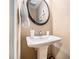 Traditional powder room featuring a pedestal sink, neutral walls, and an oval mirror at 1156 Magnolia Dr, Villa Rica, GA 30180